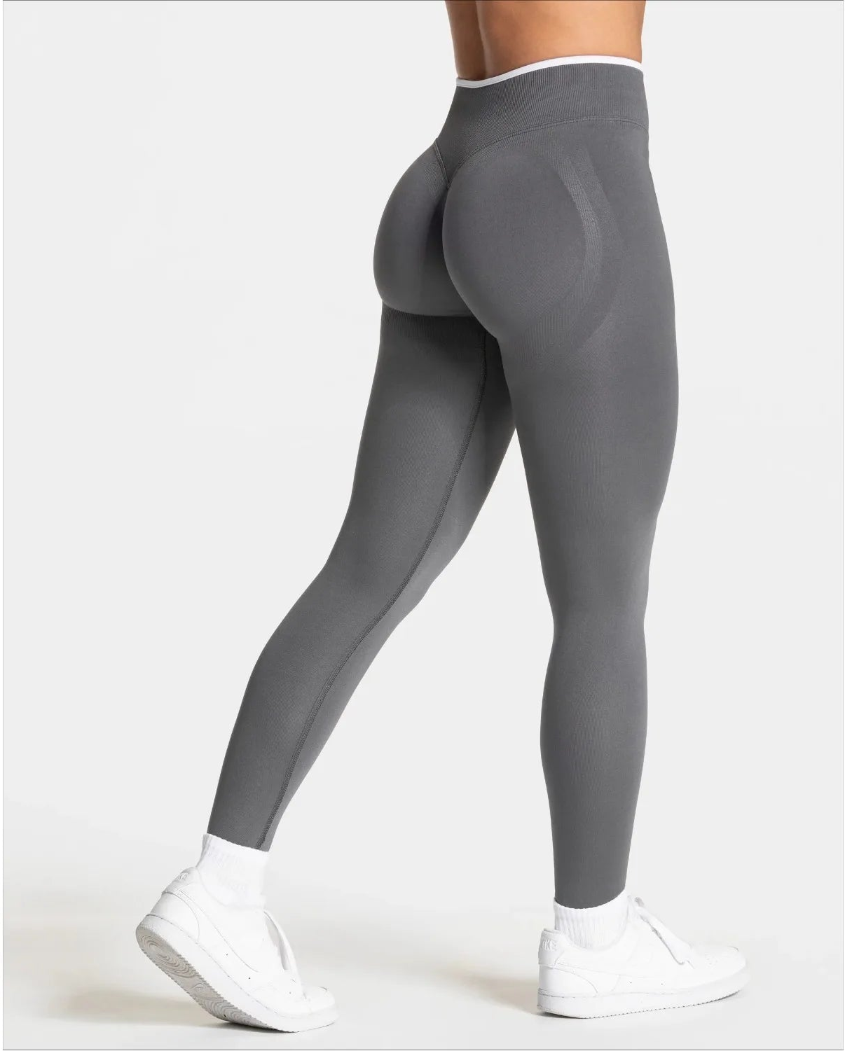 Gray leggings worn by a person on a white background